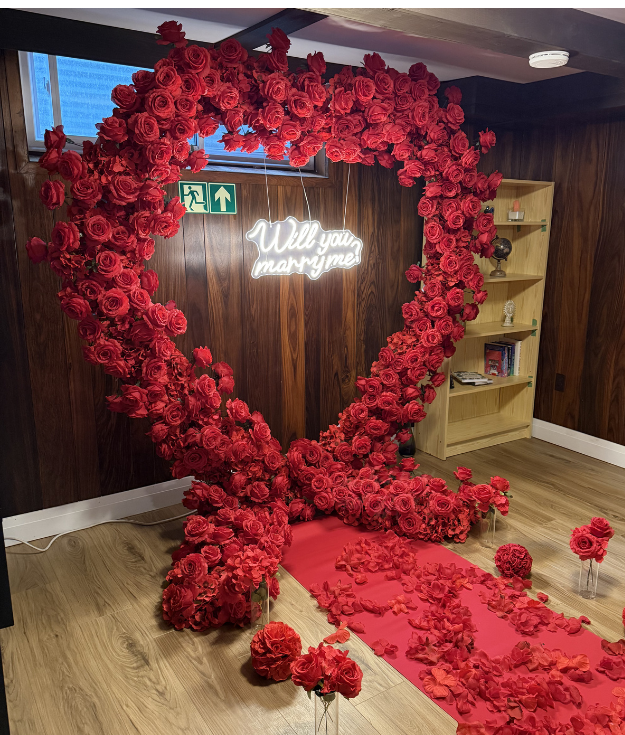 Red heart-shaped flower wall for romantic wedding proposals and photo moments