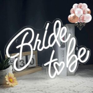 Neon sign reading ‘Bride to Be’ in elegant script, glowing against a lush flower wall