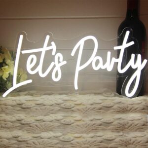 "Let’s Party neon sign in stylish script, glowing against a vibrant flower wall backdrop