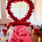 Romantic proposal setup featuring a white flower wall backdrop with candles, rose petals, and custom signage — perfect for engagements in Vaughan and the GTA.