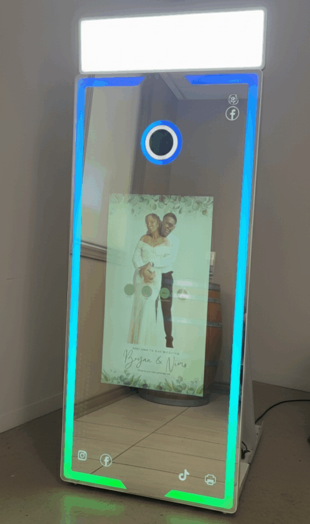 Lively party guests enjoying a mirror photo booth as confetti rains down around them, indicating celebration and excitement