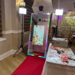 Modern photo booth setup with backdrop, props, and instant photo printing station for event rentals