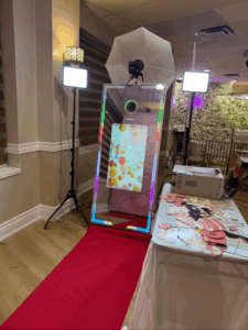 Modern photo booth setup with backdrop, props, and instant photo printing station for event rentals